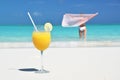 Glass of orange juice on the sandy beach Royalty Free Stock Photo