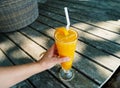 a glass of orange juice on the sandy beach. Fresh orange juice, fruits on sand with wooden background, summer concept Royalty Free Stock Photo