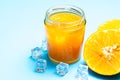 Glass of orange juice with sliced orange fruit and ice cubes on blue Royalty Free Stock Photo