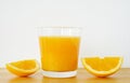 Glass of orange juice with sliced orange on wooden table Royalty Free Stock Photo