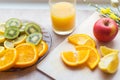 A glass of orange juice on the table, a plate of fruit