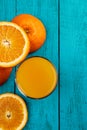 Glass of orange juice on wooden table with fresh sliced fruits of orange. Royalty Free Stock Photo