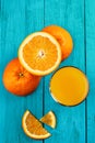 Glass of orange juice on wooden table with fresh sliced fruits of orange. Royalty Free Stock Photo