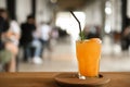 Glass of orange juice on a wooden tray placed on a table in the cafe blurred background Royalty Free Stock Photo