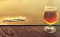 Glass of original Dutch beer on bar desk against Amsterdam waterway at sunset light Royalty Free Stock Photo