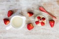 Glass of overnight oats with strawberries and milk jug on wooden background. Royalty Free Stock Photo