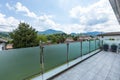 A glass parapet of a modern building balcony overlooking hills