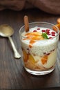 Glass of parfait made from Greek yogurt with Mixed, peach, red currant, honey and chia on a wooden backgrounds. Healthy