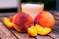 Glass of peach yoghurt and peaches on wooden table Royalty Free Stock Photo