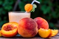 Glass of peach yoghurt and peaches on wooden table Royalty Free Stock Photo