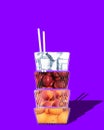 Glass with peaches, apples, water, oranges and ice over purple background. Creative design. Lemonade ingredients