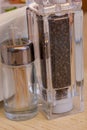 Glass pepper shaker and toothpicks on wooden table