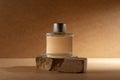 Glass perfume bottle or home fragrance on natural stone podium