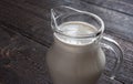 A glass picher with milk on the wooden table Royalty Free Stock Photo