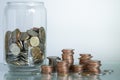 Glass piggy bank and coin stacks on table Royalty Free Stock Photo