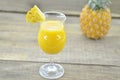 Glass of pineapple juice, fresh pineapple and slices on wooden table Royalty Free Stock Photo