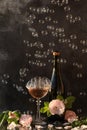 Glass of pink champagne with rose flowers on the black background with bubbles Royalty Free Stock Photo