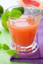 Glass of pink grapefruit juice with lemon mint