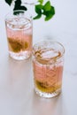 A glass of pink wine in a crystal glass on a marble background, green ivy