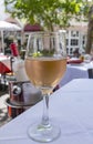 Glass of Pink Wine Sitting on a White Linen Covered Table of a Restaurant
