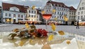 Glass of pink wine yellow autumn leaves on street restaurant glass table top rainy drops on window town hall square in Tallinn Ol