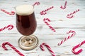 A glass, pint of beer or ale on a white rusty table with a J shaped Candy Canes Royalty Free Stock Photo