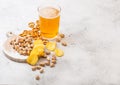 Glass pint of craft lager beer with snack on stone kitchen table background. Pretzel and crisps and pistachio on roud wooden board Royalty Free Stock Photo