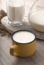 Glass, pitcher, yellow cup of kefir and napkin on a white table Royalty Free Stock Photo