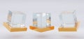 Glass or plastic cube on golden stand in different angle view. Blank clear square showcase, exhibit podium, crystal