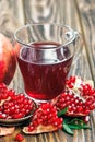 Glass of pomegranate juice with ripe fresh punica granatum fruits with leaves on wooden table Royalty Free Stock Photo