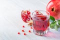 Glass of pomegranate juice and ripe pomegranate on a white wooden background. Healthy drink concept. ÃÂ¡opy space
