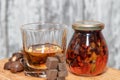 Glass of poured homemade whiskey with ingredients for cooking