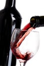 Glass poured with red wine and bottle with red wine on white Royalty Free Stock Photo