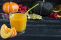 A glass of pumpkin juice and a piece of pumpkin on a rich dark background blurred background with pumpkins