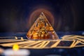 A glass pyramid with a Golden frog with magic aura. Tarot cards are scattered on the table. Close-up. Copy space. The concept of Royalty Free Stock Photo