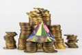 Glass pyramid stands on stacks of coins Royalty Free Stock Photo