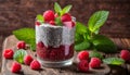 A glass of raspberry yogurt with mint leaves on a wooden table