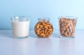 Glass of raw almonds, vegetable milk and jar with soaking nuts. Concept of making plant based organic veggie Milk, lactose free