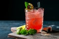 Glass of red alcoholic cocktail drink with ice, mint and lime. Summer refreshing drink Royalty Free Stock Photo