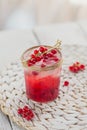Glass of red currant cocktail or mocktail, refreshing summer drink with crushed ice and sparkling water on a white wooden Royalty Free Stock Photo