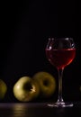 A glass of red fruit wine isolated on black. Apples fresh crop, still life in a low key. Royalty Free Stock Photo