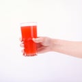 A glass with red grapefruit juice and a straw in her hand into a girl. Isolate on white background Royalty Free Stock Photo