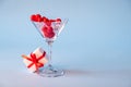 Glass with red heart shaped sugar candy and ice and gift box a blue background. Time for love.Valentines Day, Royalty Free Stock Photo