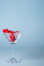 Glass with red heart shaped sugar candy and ice. Over blue background. Valentines Day, anniversary or wedding celebration concept. Royalty Free Stock Photo