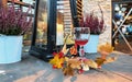 Glass of red juice lantern with candle yellow leaves on wooden table in street restaurant  in city Tallinn   old town Autumn conce Royalty Free Stock Photo