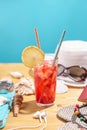 Glass of red lemonade drink with lemon and straw on the table. Accessories for summer Sunny holidays in the resort Royalty Free Stock Photo