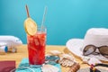 Glass of red lemonade drink with lemon and straw on the table. Accessories for summer Sunny holidays in the resort Royalty Free Stock Photo