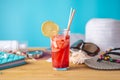 Glass of red lemonade drink with lemon and straw on the table. Concept of a bright summer Sunny holiday in the resort Royalty Free Stock Photo