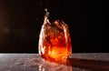 Glass of a red and orange splashing alcoholic drink on a dark background Royalty Free Stock Photo
