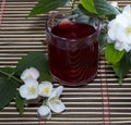 Glass of red tea on a rug with a flower Royalty Free Stock Photo